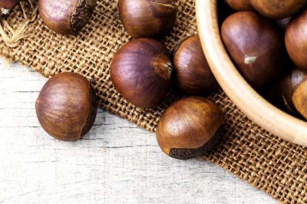 Des marrons rôtis sur un sac et un bol.