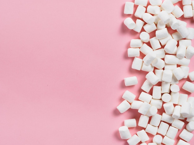 Des marshmallows sur fond rose avec un espace de copie