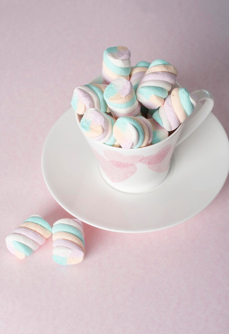 Photo des marshmallows roses claires et blanches dans de belles tasses en céramique avec des cœurs roses