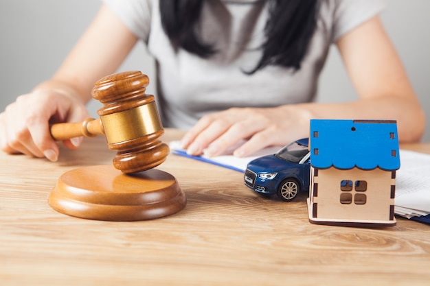 Marteau du juge, voiture et maison sur la table