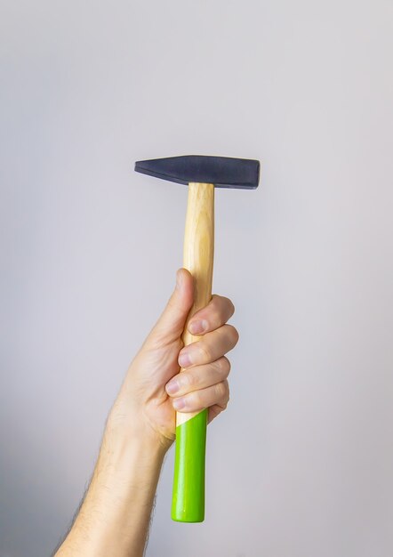 Marteau entre les mains d'un homme isoler. Mise au point sélective.