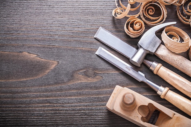 Marteau à griffes de rabot ciseaux plus fermes en métal et copeaux de bois recourbés sur le concept de construction de planche de bois vintage.