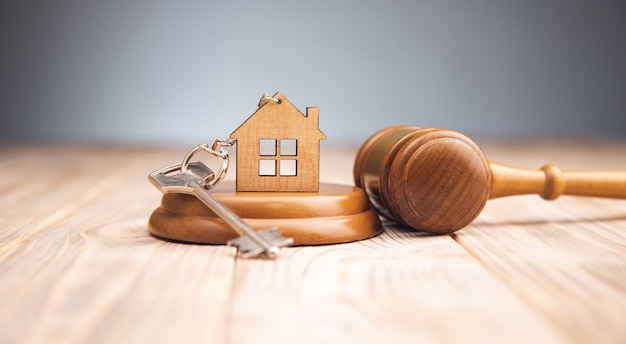 Photo marteau de juge et clé de la maison sur bois