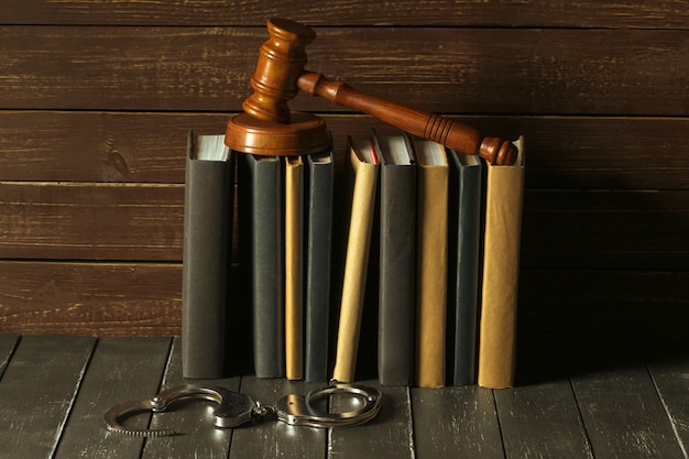 Marteau avec des livres sur le vieux bureau en bois