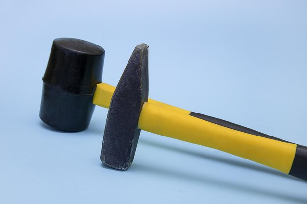 marteau et marteau sur un fond bleu clair le concept d'outils de construction réparation brutalité