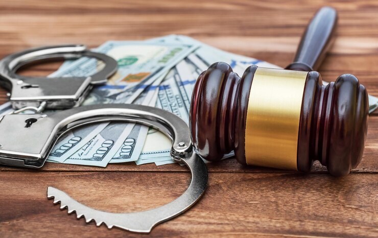 Photo marteau avec des menottes et de l'argent sur la table en bois concept de crime et de droit