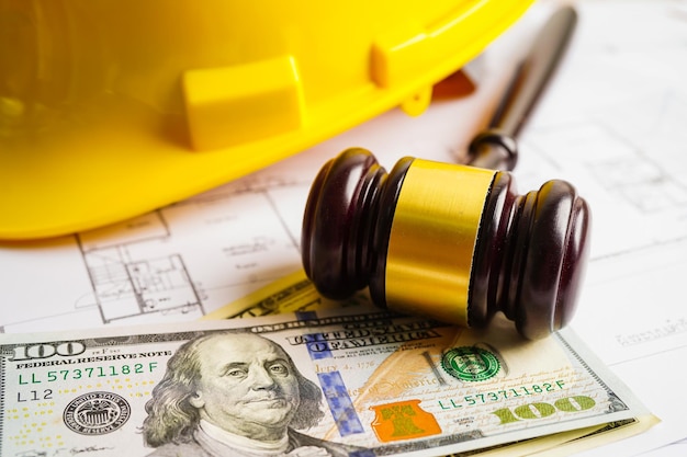 Marteau pour juge avocat avec casque de construction et billets en dollars américains pour un projet de travail au bureau