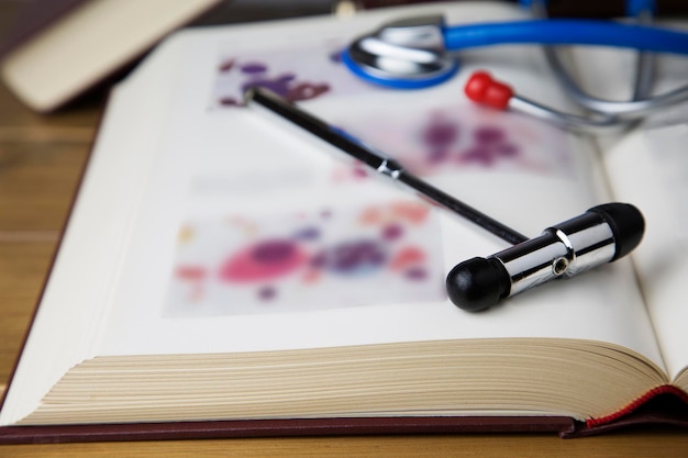 Marteau réflex par stéthoscope sur livre sur table