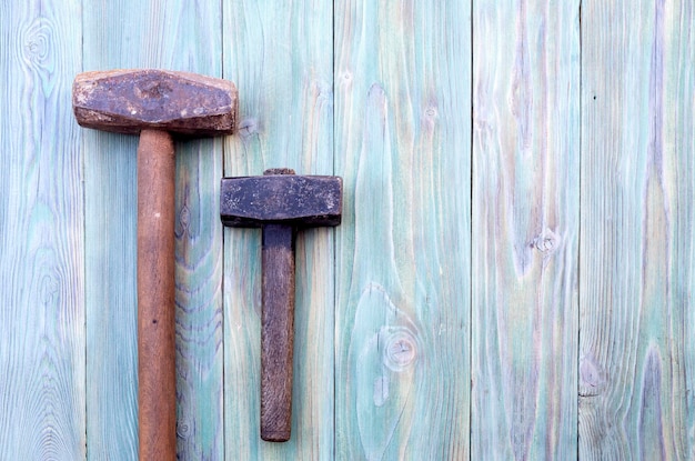 Marteau vintage et marteau de forgeron sur un gros plan de fond en bois