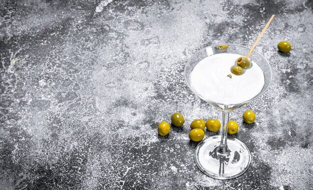 Martini aux olives sur une table rustique.