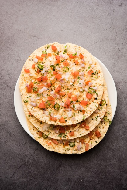 Masala Papad orÃ‚Â papadumÃ‚Â est une délicieuse collation indienne à base de papad rôti ou frit surmonté d'un mélange de tomates à l'oignon et épicé