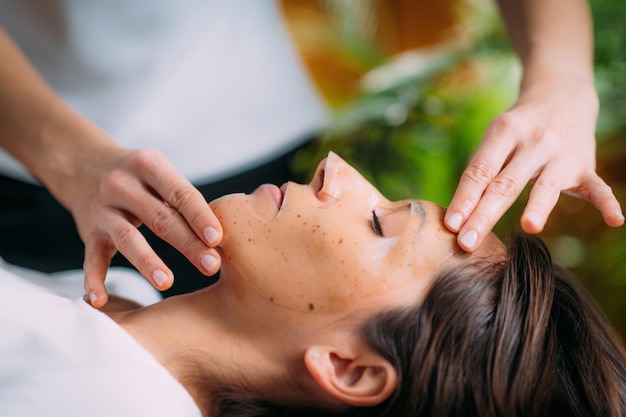 Masque de beauté sur le visage de la femme dans le salon