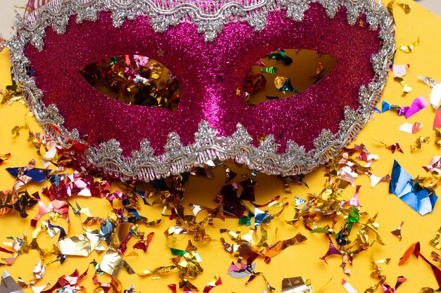 Photo masque de carnaval coloré sur fond jaune avec plusieurs ornements