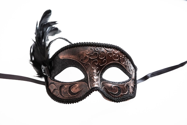 Masque de carnaval couleur marron avec décoration plume noire isolé sur fond blanc