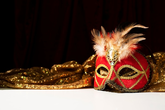 Photo masque de carnaval devant un textile doré