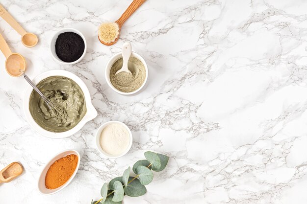 Masque facial à l'argile fait maison. Zéro déchet écologique diy produits de beauté ingrédients sur mur léger, pose plate, vue de dessus