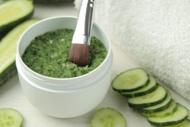 Masque facial au concombre. Cosmétiques à l'extrait de concombre sur une table en bois blanc. spa. beauté.