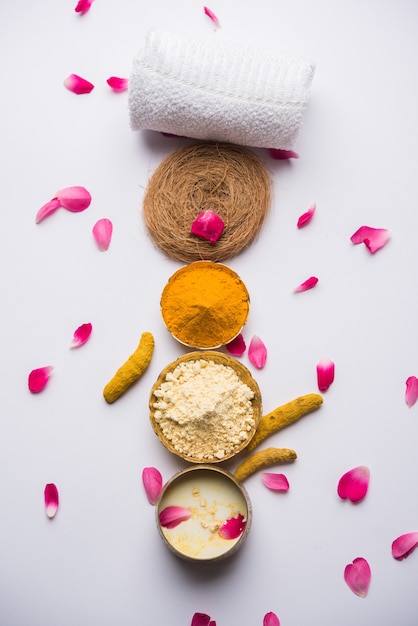 Masque facial ou masque ayurvédique utilisant Gram Flouror besan, Haldi et lait ubtan placés dans des bols en laiton avec des pétales de rose, un gommage et une serviette blanche. mise au point sélective