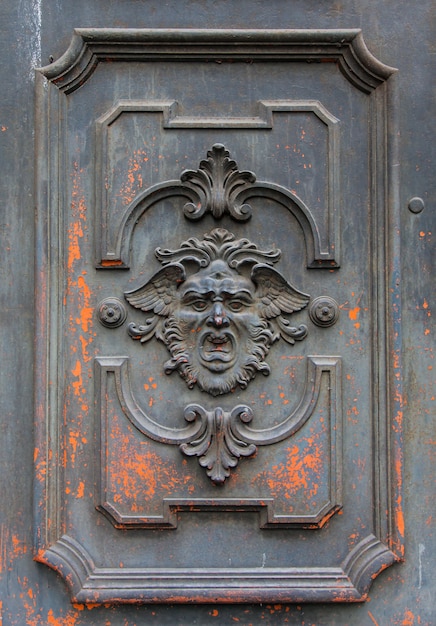 Masque gothique sur une vieille porte en bois à Milan - Italie