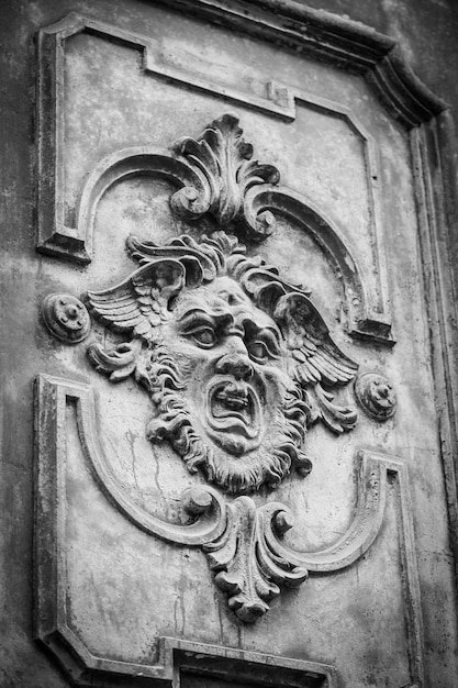 Masque gothique sur une vieille porte en bois à Milan - Italie