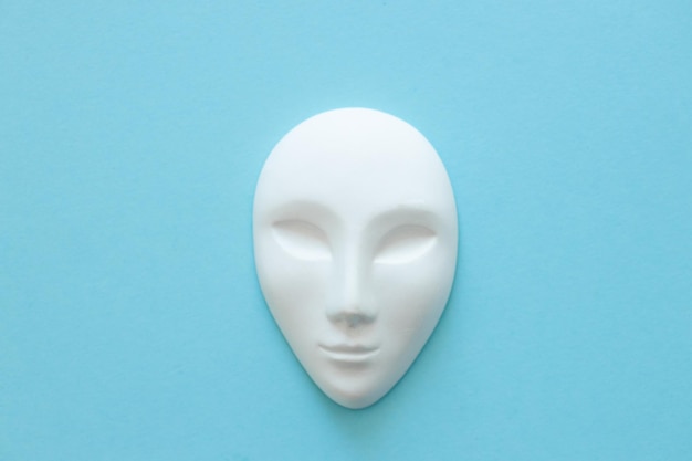 Masque de gypse blanc humain aux yeux fermés sur fond bleu