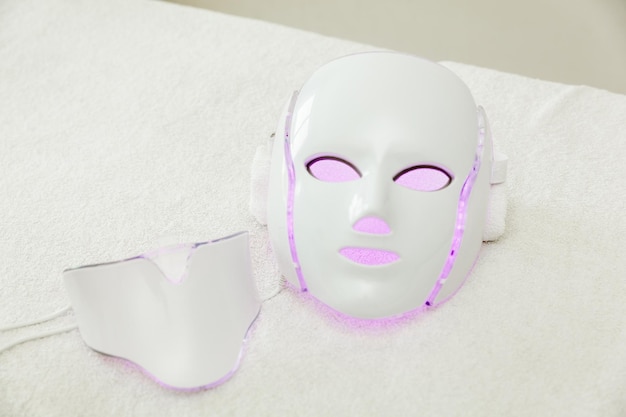 Photo le masque led pour le rajeunissement du visage brille dans différentes couleurs