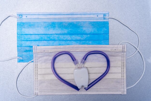 Masque de médecine avec éjecteur de salive en forme de coeur Stomatologie et concept de soins bucco-dentaires