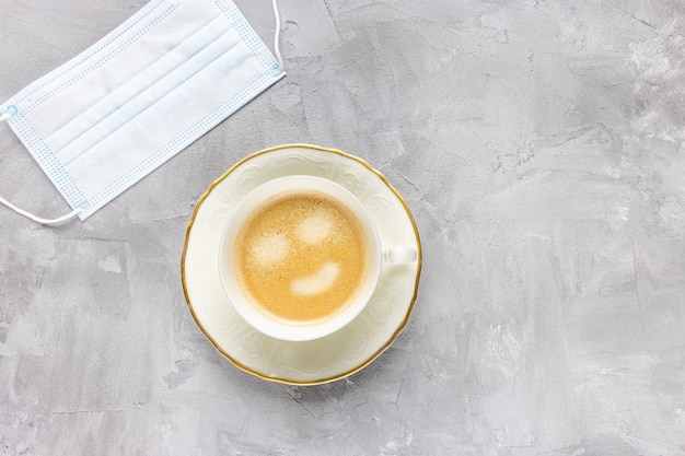 Masque médical blanc et tasse de café