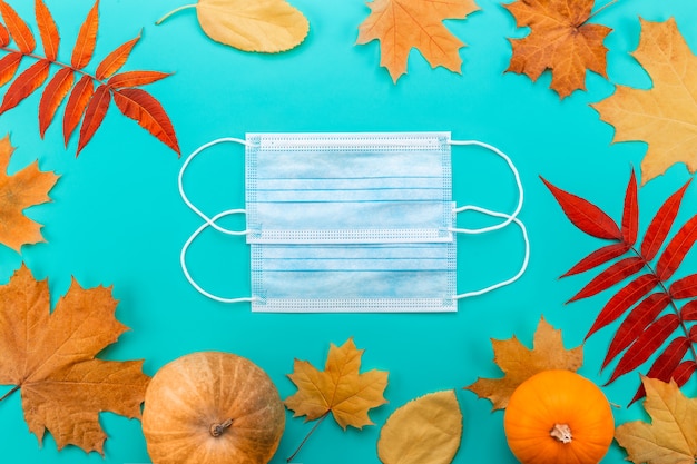 Masque médical entre les feuilles d'érable isolées