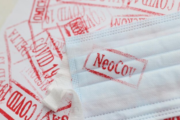 Masque médical de protection avec une nouvelle variante du coronavirus neocov allongé sur la surface