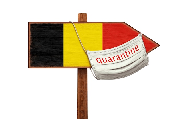 Un masque médical avec QUARANTAINE est suspendu à un pointeur de panneau avec l'image du drapeau de la Belgique