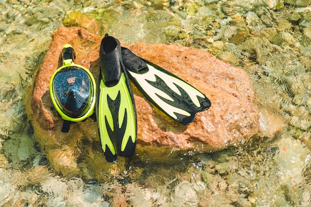 Masque de plongée en apnée avec palmes au rocher dans l'espace de copie d'eau de mer