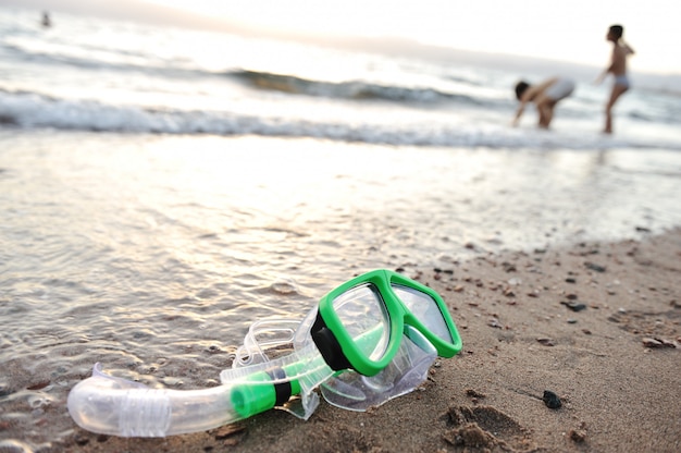 Masque de plongée en apnée sur la plage, les enfants jouent autour