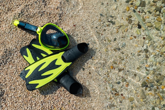 Masque de plongée avec palmes en mer plage