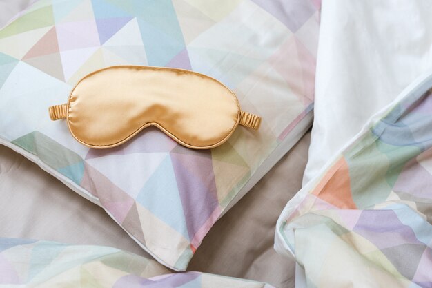 Masque pour les yeux dorés sur le lit