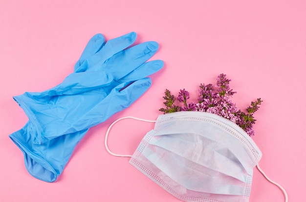 Masque protecteur avec fleurs et gants en nitrile bleu.