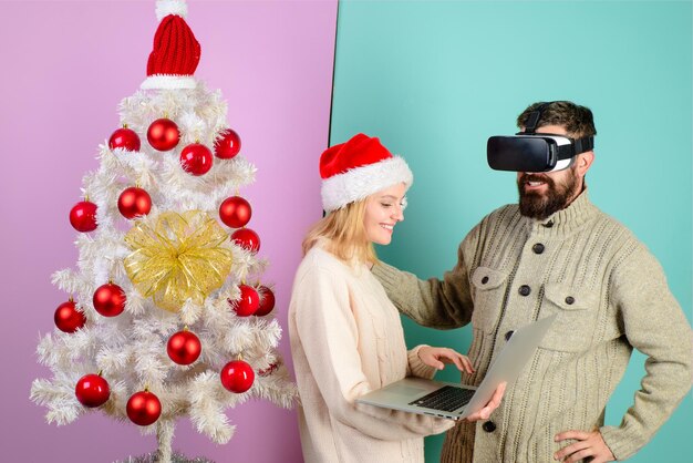 Masque de réalité virtuelle nouvel an noël futur et concept technologique femme en bonnet de noel avec ordinateur portable