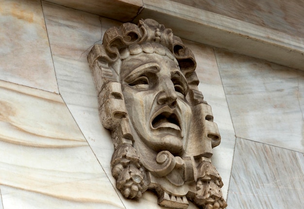 Photo masque de théâtre avec expression de tristesse sur le mur