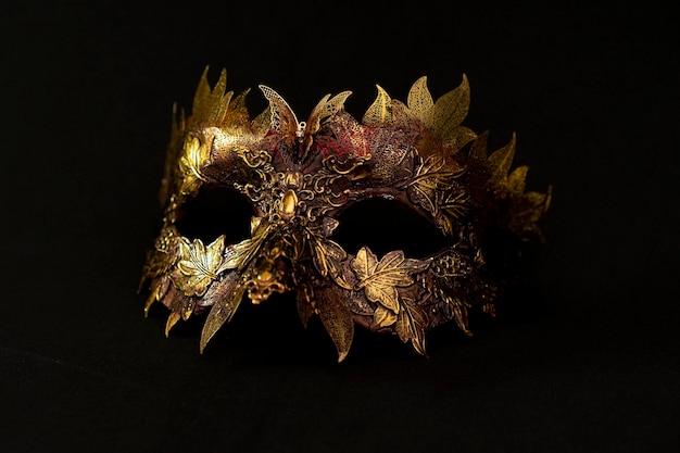 Masque vénitien en or et rouge avec des pièces métalliques en forme de feuilles. design original et unique, artisanat fait à la main