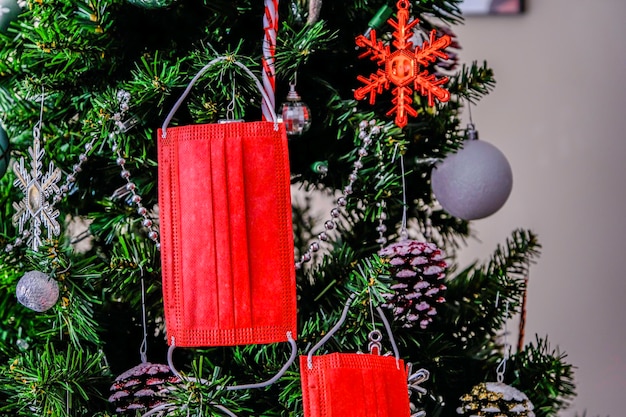 Masques rouges accrochés à un sapin de Noël