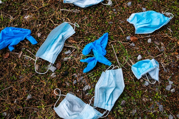 Masques sales et gants médicaux sur l'herbe Déchets dangereux