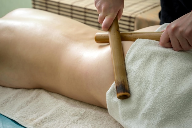 Massage avec des bâtons de bambou sur son dos