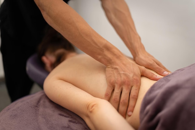 Photo massage concentré du dos par un masseur professionnel