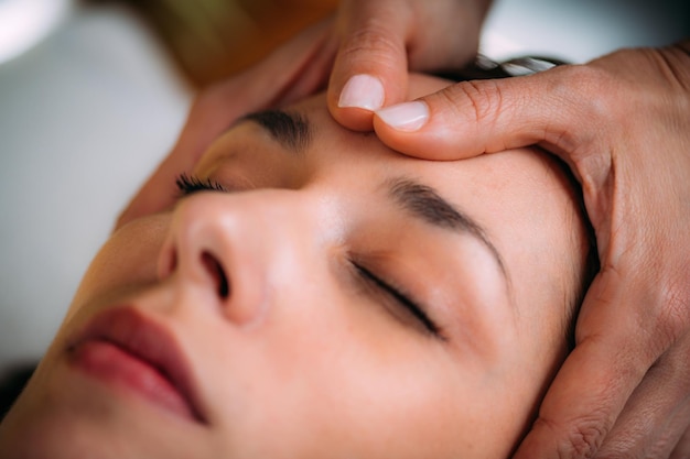 Photo massage craniosacral par un thérapeute cst massant la tête d'une femme