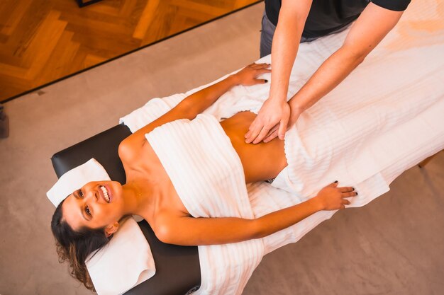 Massage à domicile un jeune homme effectuant un massage au domicile du client