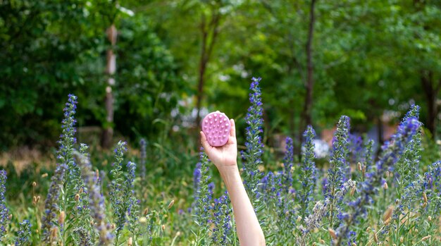 massage du cuir chevelu stimulant la croissance des cheveux sur fond d'herbe verte jardin utilisant le cuir chevelu rose