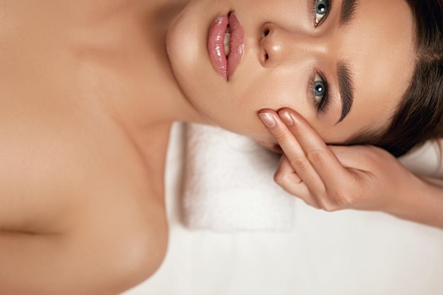 Massage du visage Belle de jeune femme recevant un traitement de massage spa au salon de beauté Spa