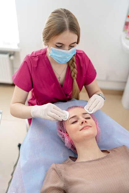 Massage du visage en cabinet de cosmétologie. Esthéticienne fournit des procédures de beauté dans une clinique de beauté.