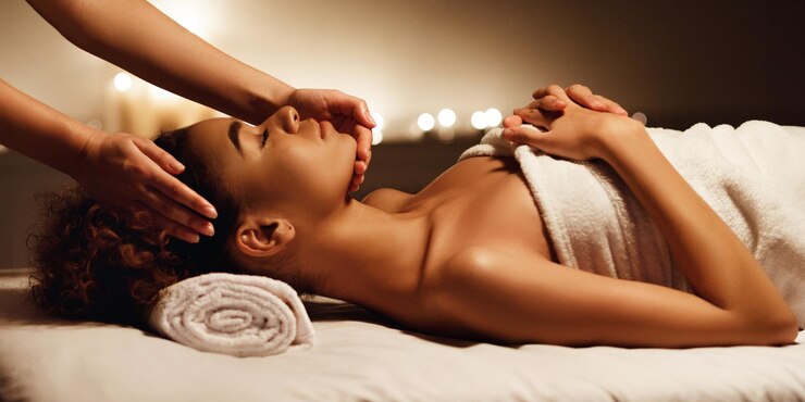 Photo massage du visage femme afro-américaine recevant un traitement de spa