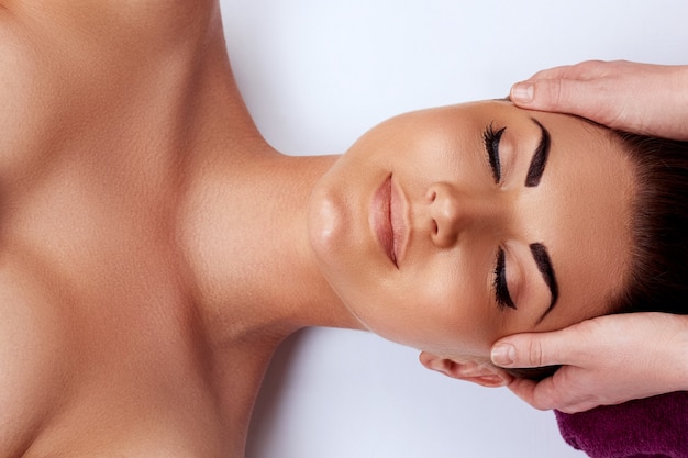 Massage du visage. Gros plan, de, jeune femme, obtenir, traitement spa, massage, à, beauté, spa, salon